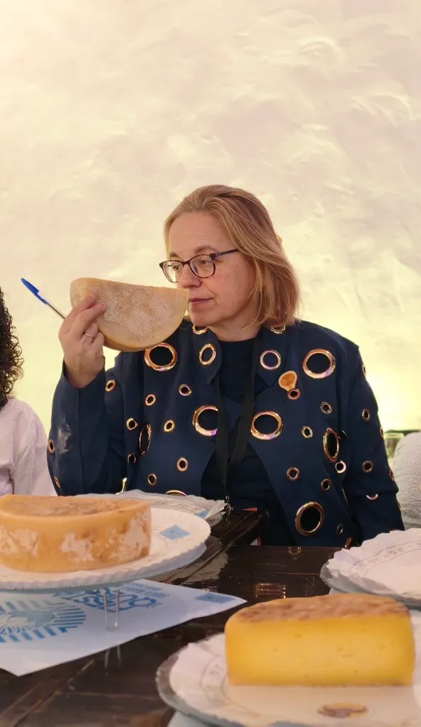 Ruth Lozano smells a wedge of cheese, eyes lowered in concentration, during the olfactory phase of a competition tasting.